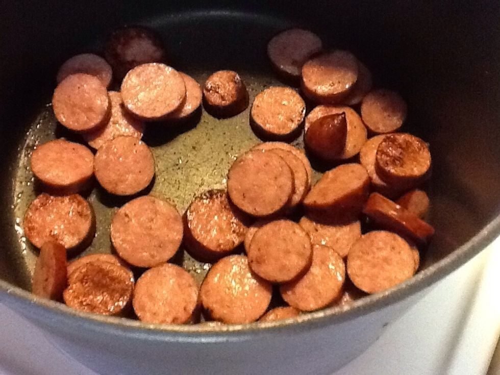 Cut andouille in circular pieces and sweat in stock pot. It's important to cook everything in one pot.