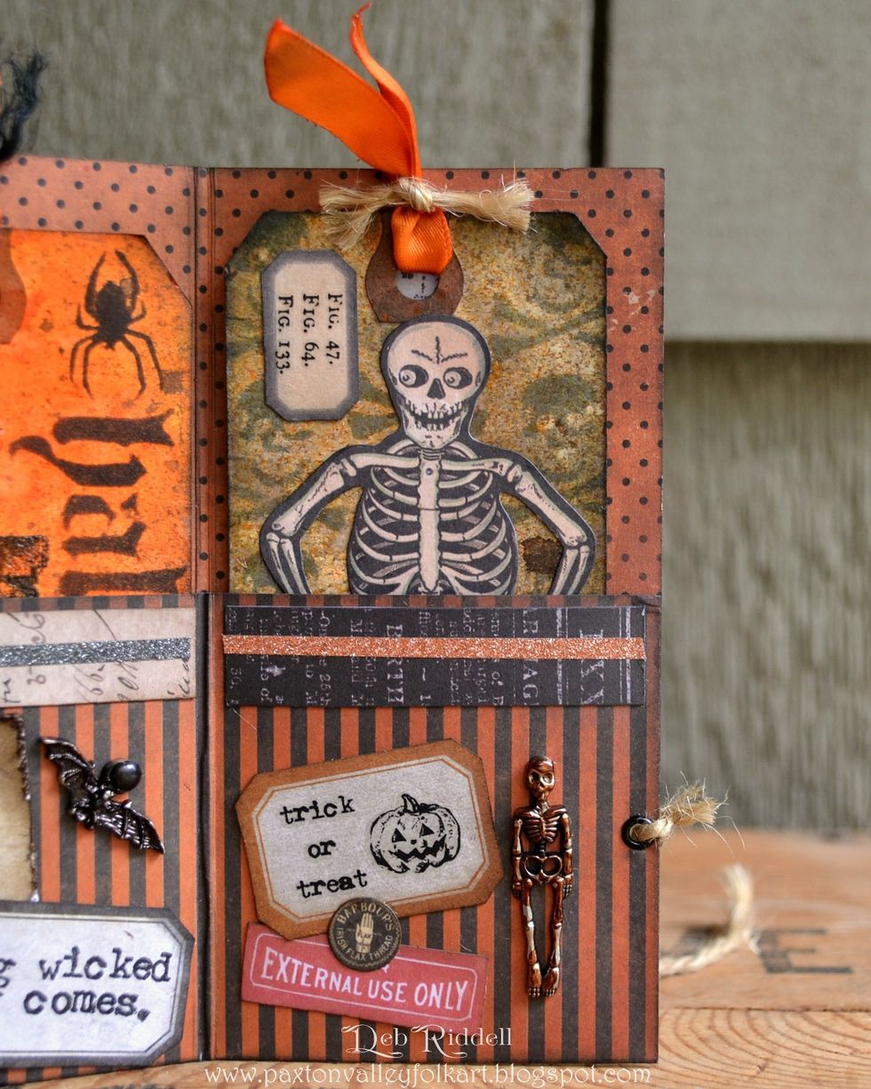 Cut another paper strip and label from Regions Beyond paper and add Curiosities Remnant Rubs to the label. Choose some elements from the Frightful Ephemera pack and layer.