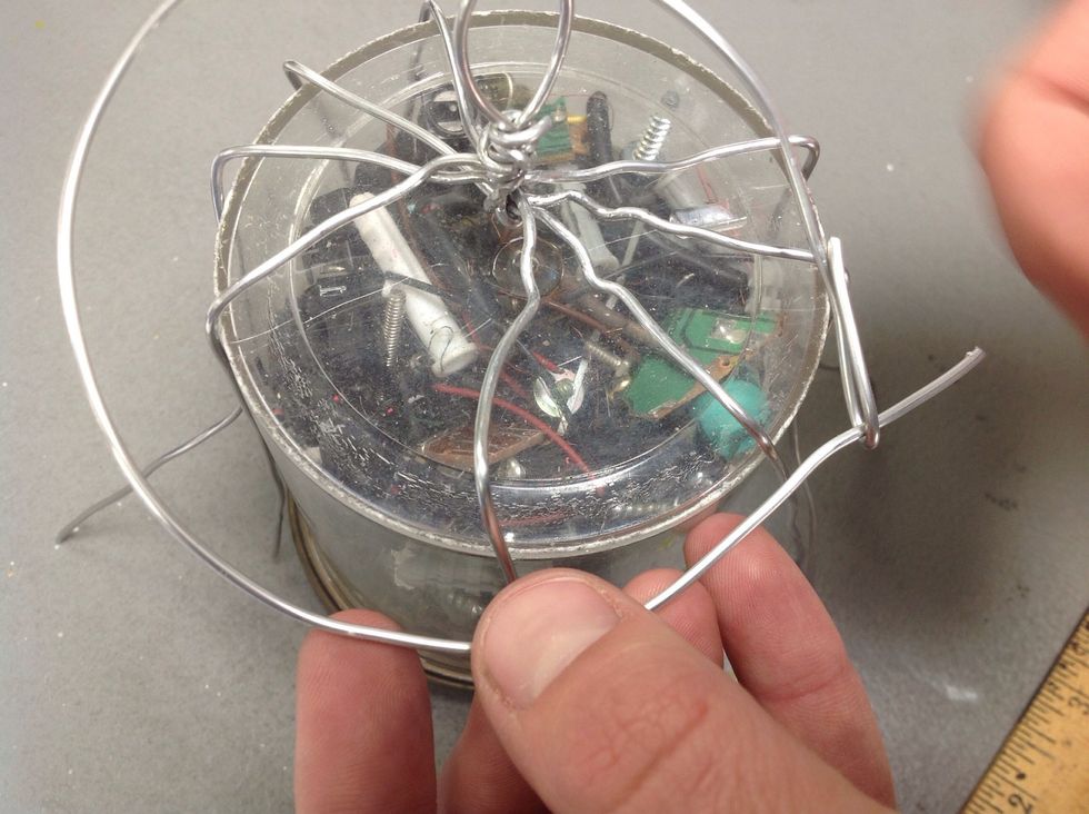 Cut another piece of wire long enough to fit around the cylinder. Attach the two ends to make a circle that will fit.