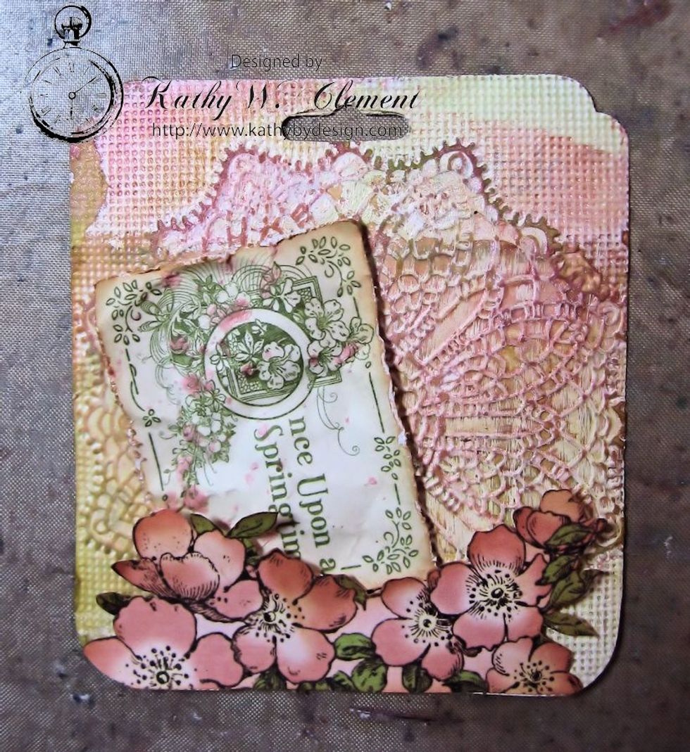 Cut apart the images from the Enchanted Forest page. Ink the edges with Vintage Photo. Spritz with water. Crumple. Unfold. Spatter w/Glimmer Mist. Glue the bottom edge & use foam dots on top edge.