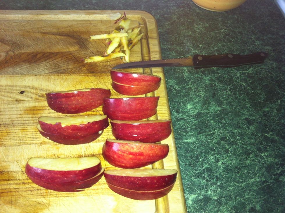 Cut apple into 8 sections an then cut them in the middle to where the bottom half has a flat plane when it's lying on the counter