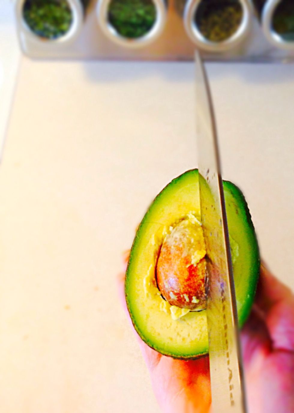 Cut avocado in half. This is the easiest way to remove the seed: stick the knife and twist