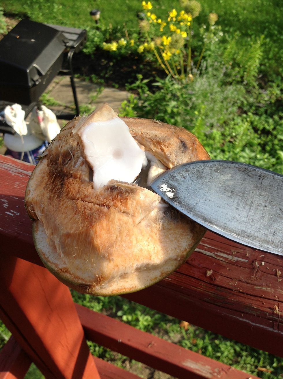 Cut away the husk until the actual coconut is exposed. The break the shell with the cutlass