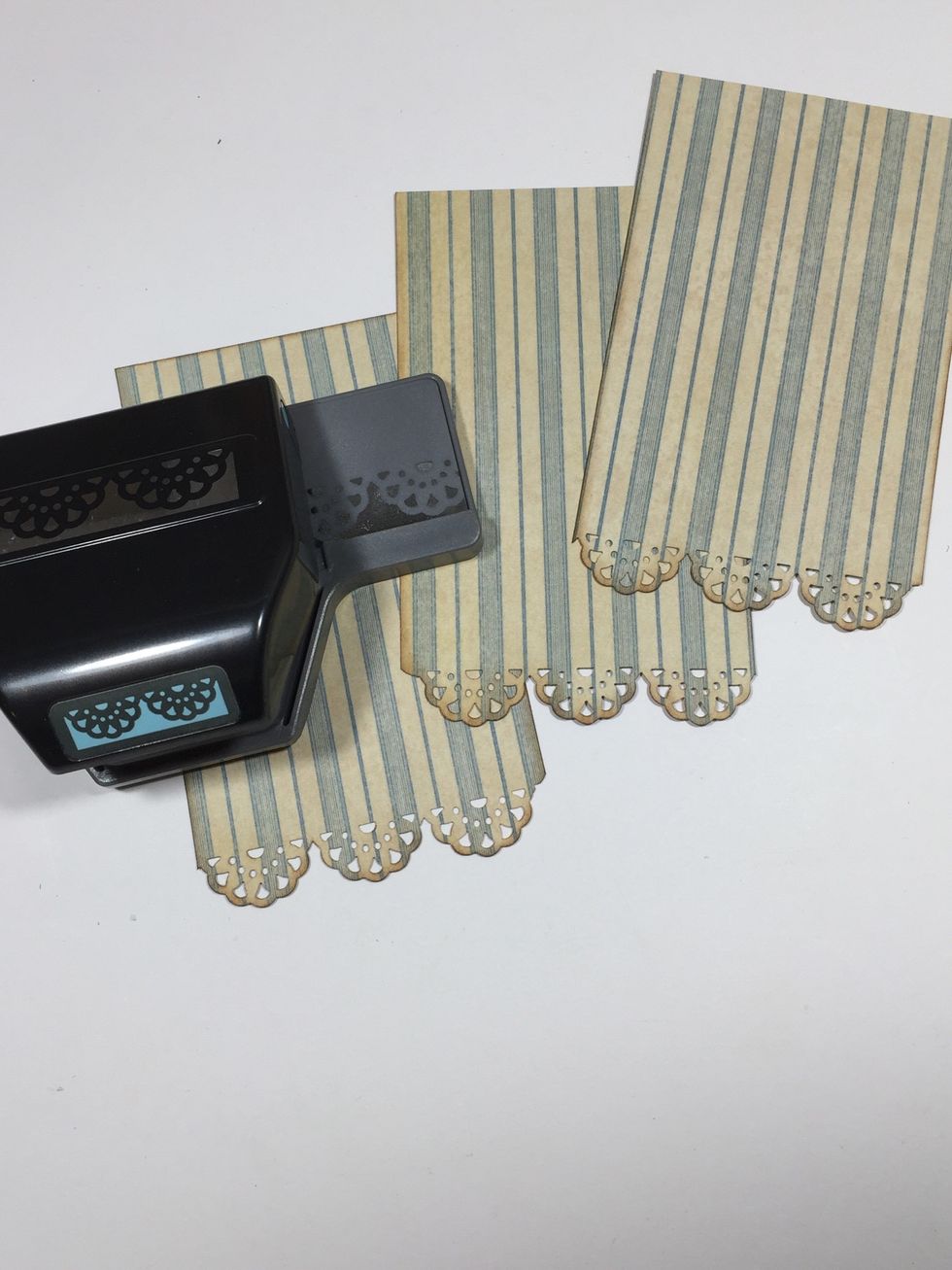 Cut blue striped paper pieces for each tag, measuring 2 7/8" x 4 3/4". Punch the bottom edge with a decorative border punch.