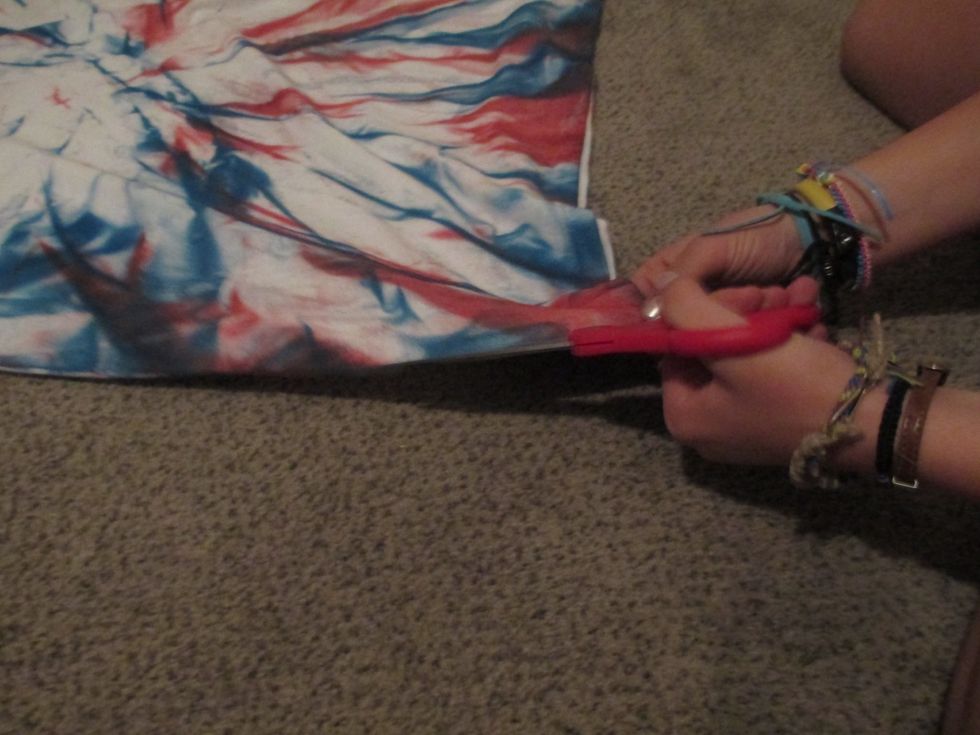 Cut both sides of the t-shirt, starting at the bottom, and going all the way to the arm. Do not separate the two sides.