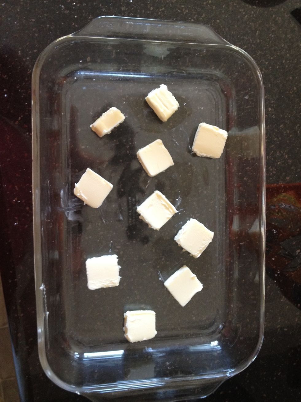 Cut butter into cubes. Place in a 9 x 13 glass dish. Put in oven.