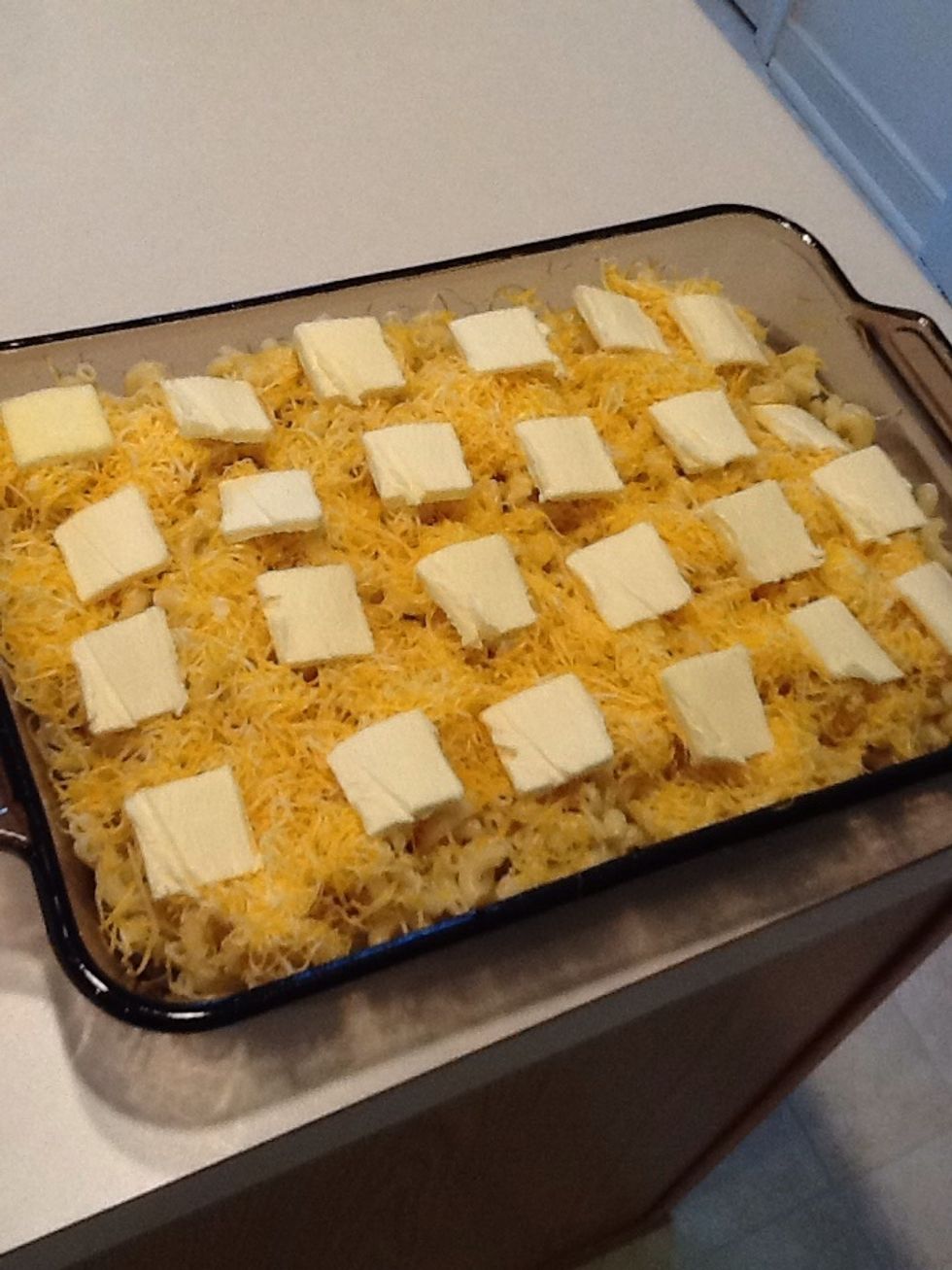 Cut butter into slices and place on top of macaroni and cheese.