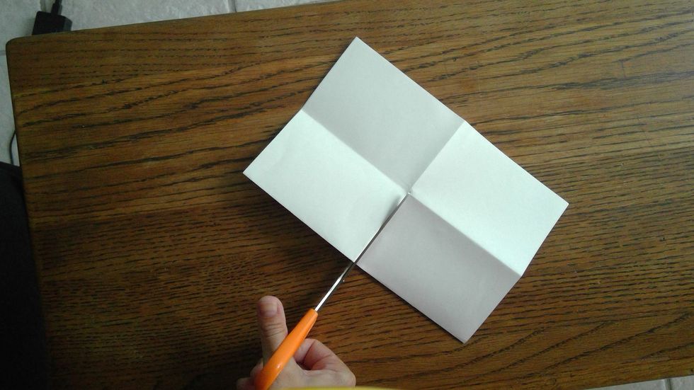 Cut carefully until you come to the point where the folds meet. Do not cut all the way through to the other side of the paper.