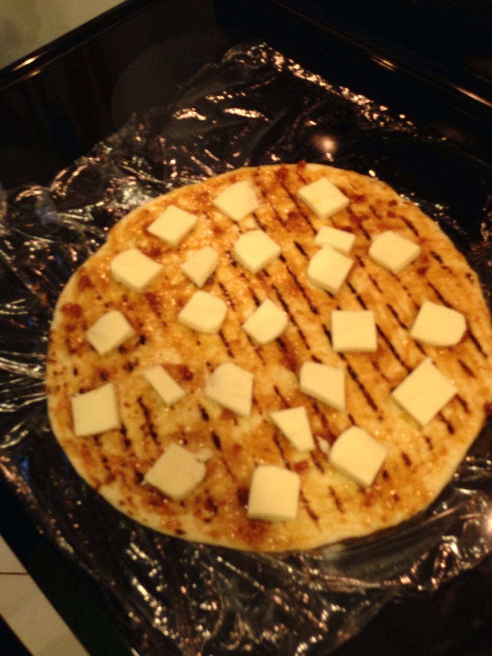 Cut cheese into squares all over the pizza. Not so close to the side because it will ooze over. Use the packaged mozzarella not the wet one in brine.