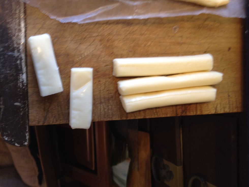 Cut cheese sticks in half.