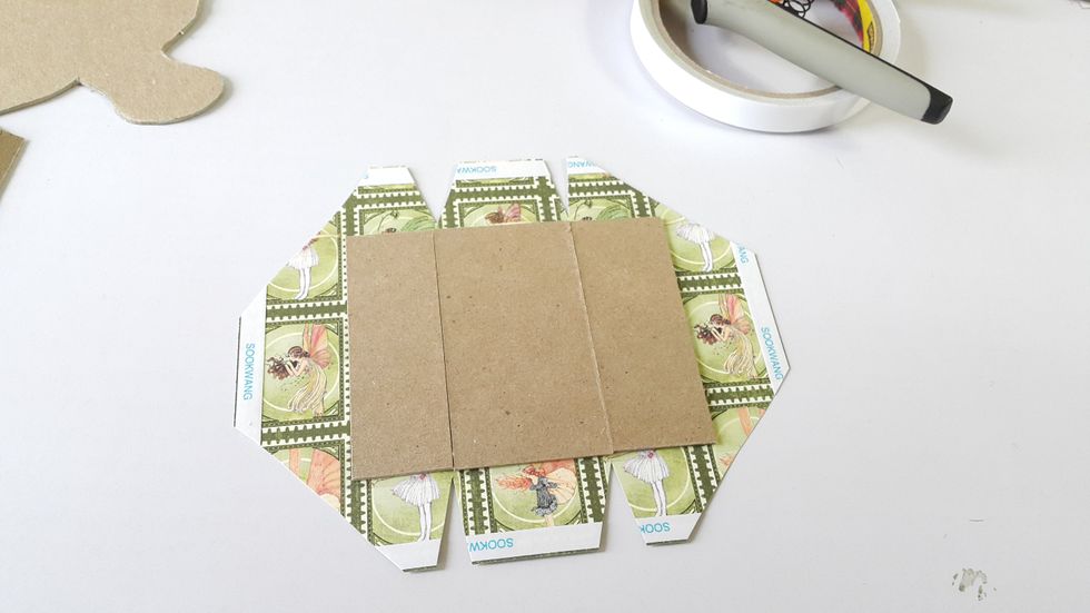 Cut chipboard to make the holder for candle according to the measurements on the template with 3" width, cover one side with paper