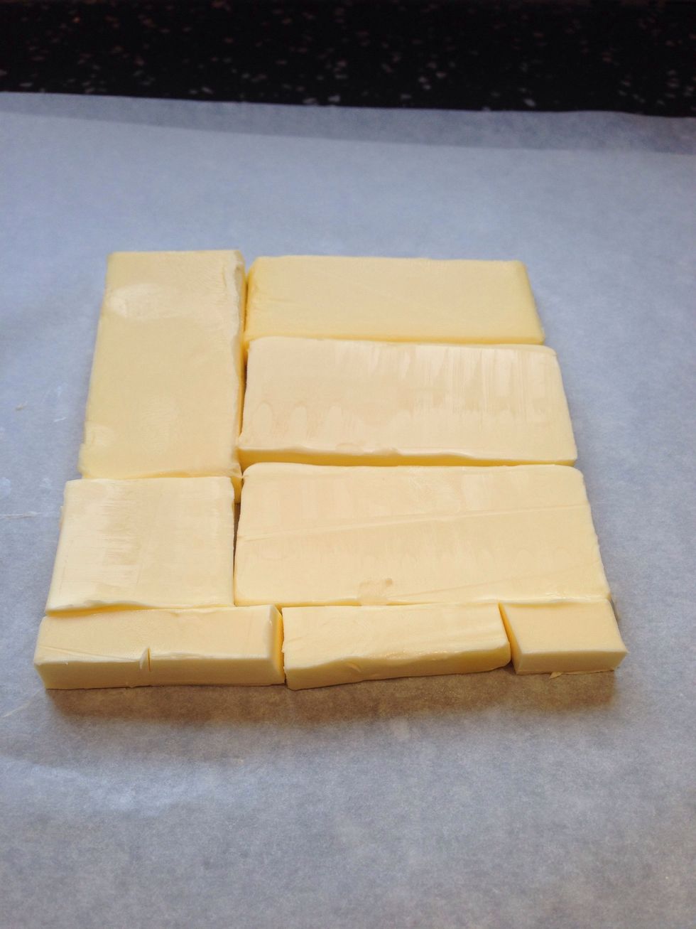 Cut cold butter from the fridge lengthwise into 1.25cm thick slabs. Arrange in waxed paper to form a square of about 15x15cm. Cover with waxed paper and pound with rolling pin until it's 19x19 cm