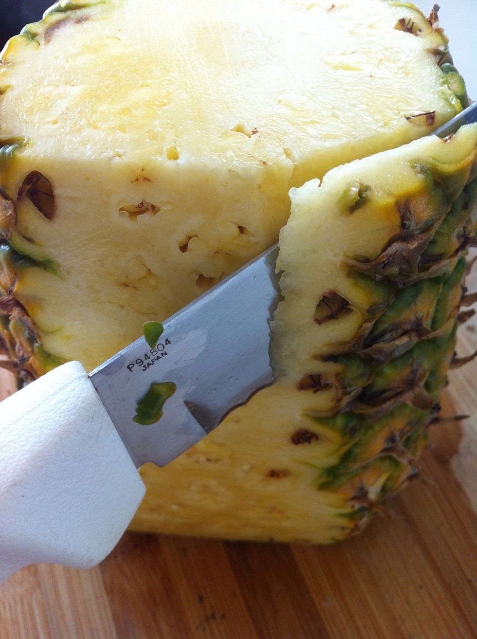 Cut down the sides of the pineapple deep enough to remove all of the rind.