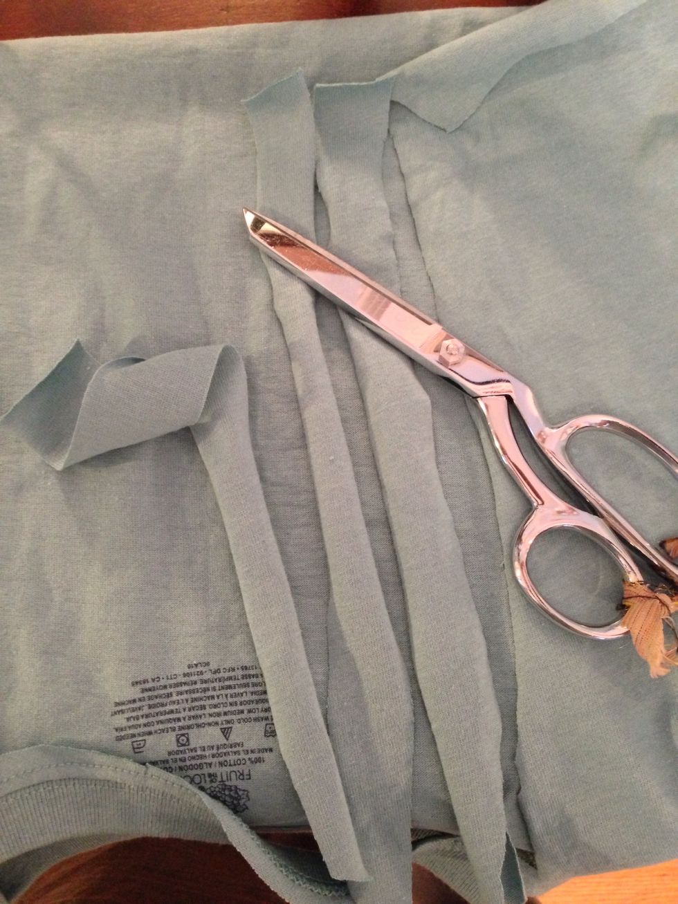 Cut enough 1" strips from what you cut off the smaller T to equal the width of the bottom of your smaller T-shirt.