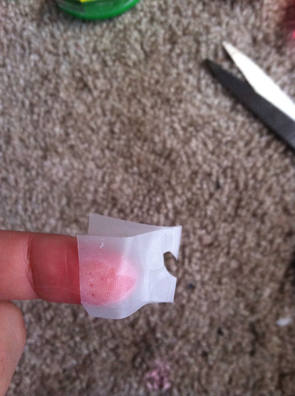 Cut half of a heat into it. Make it's small enough to fit on the nail you desire to put it on.