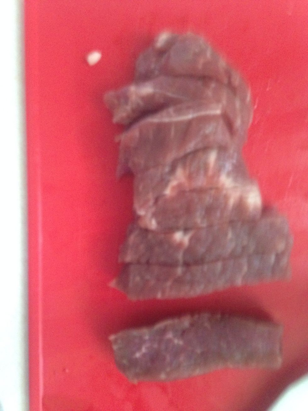 Cut into thin strips and if is a wide steak cut into half long ways