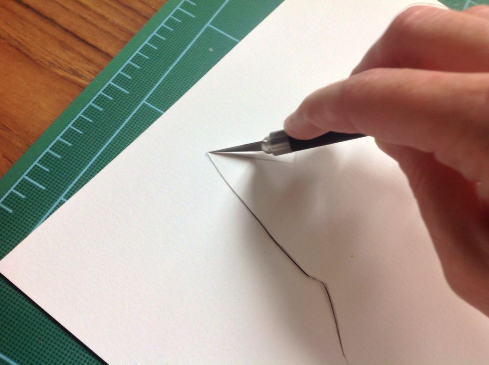 Cut it out with an exacto knife and a self healing mat. Or you can use part of an old phone book or magazine to protect your working surface.