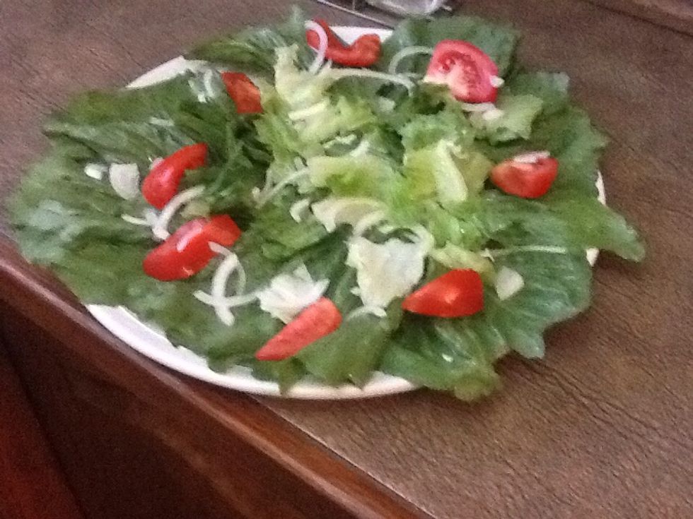 Cut lettuce, tomato, onion, garlic, add salt, pepper, olive oil