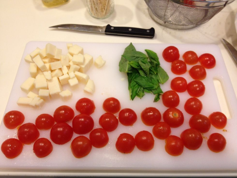 Cut mozzarella in to small cubes, slice cherry tomatoes in half & wash basil.