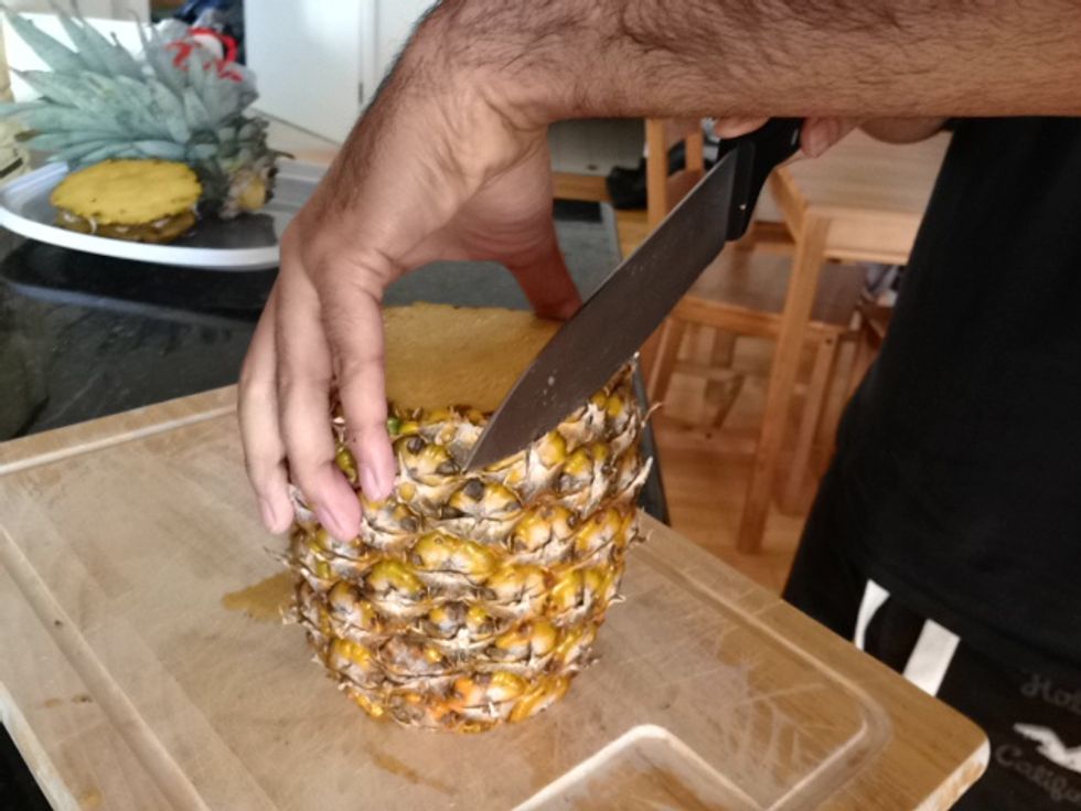 Cut off side of pineapple.