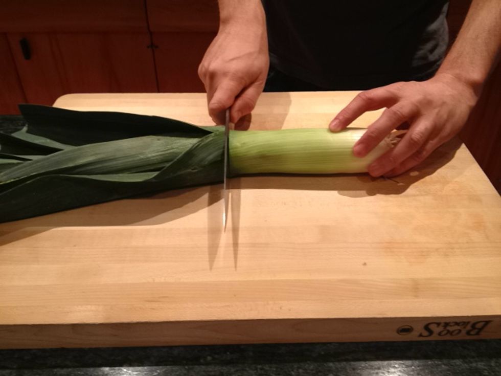 Cut off the leaves (also known as fronds.) You want to preserve as much of the light parts of the leek as possible.