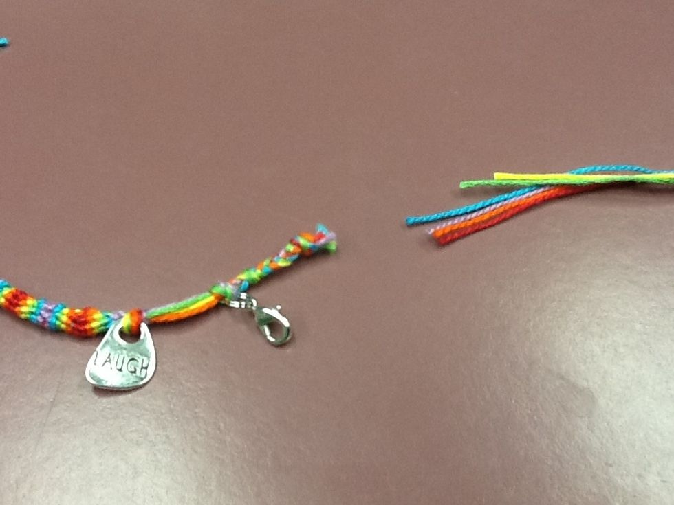 Cut off the long ends. Then you can braid the remaining ends of the bracelet.