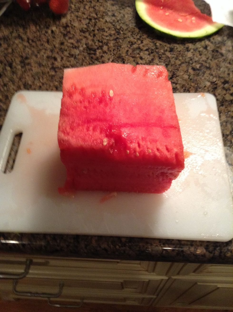Cut off the rind so the flesh of the watermelon will look like a cube. Level off the top and bottom to make a perfect cube.