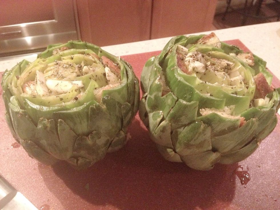 Cut off the stem so it sits nicely. Cut off a little bit of the tip also to make stuffing the artichokes easier.