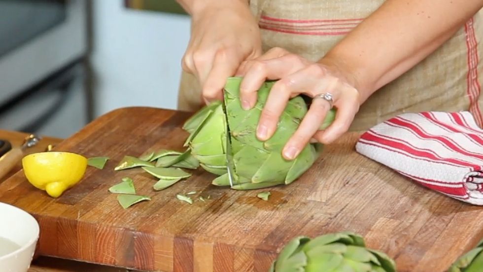 Cut off the top third of the artichoke. This will remove most of the barbs at the tips of the leaves as well as the inedible portion of the artichoke. Turn the artichoke occasionally, as you cut.