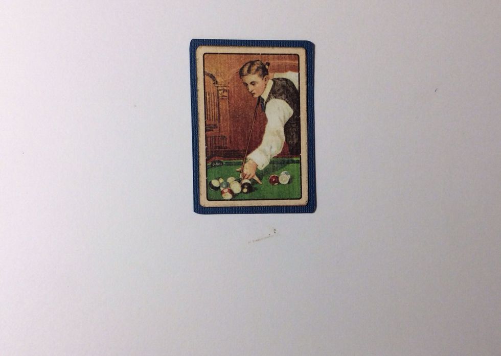 Cut one collector card from the paper collection and mount on blue card stock. Trim all the way round to form a small border.