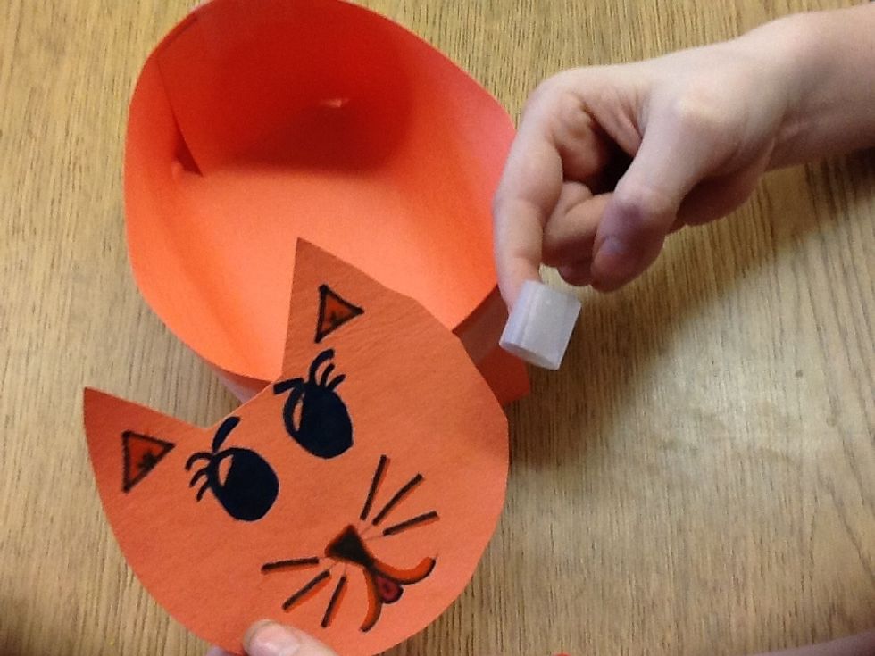 Cut out a cat face color it and tape it to the basket