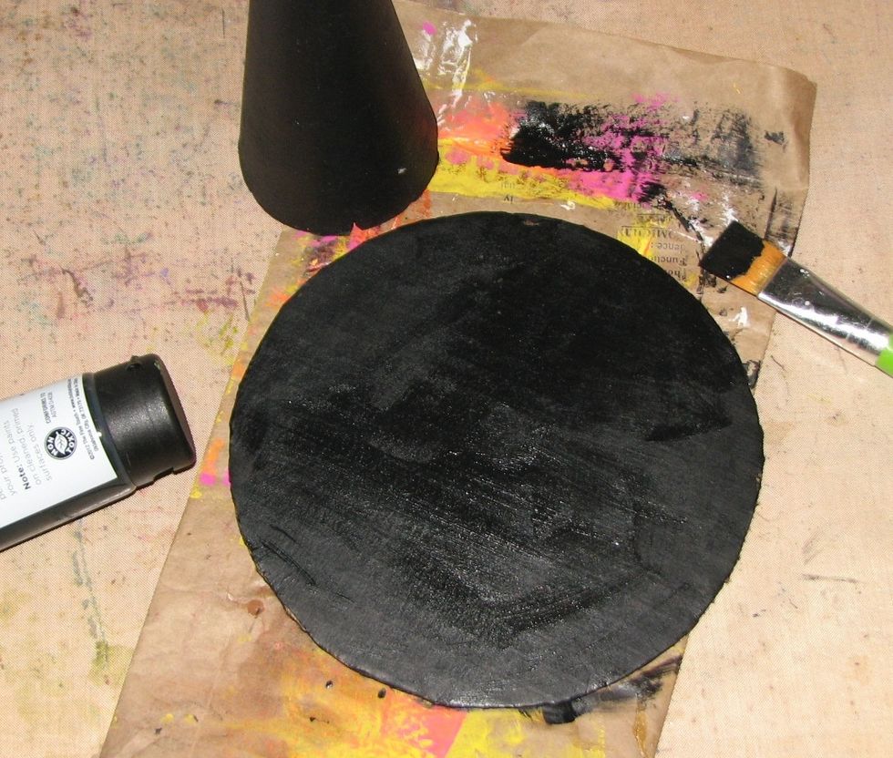 Cut out a circle from the chipboard/corrugated cardboard. Paint both the top and bottom of the circle with black paint.