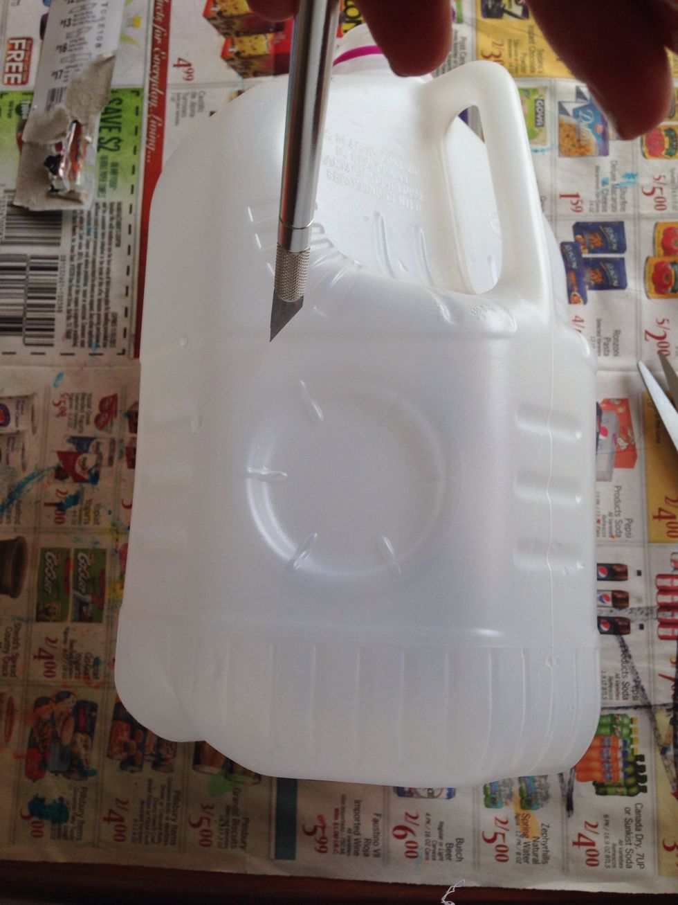 Cut out a hole in the back of the jug where the handle is. It needs to be big enough to put the string of lights in.