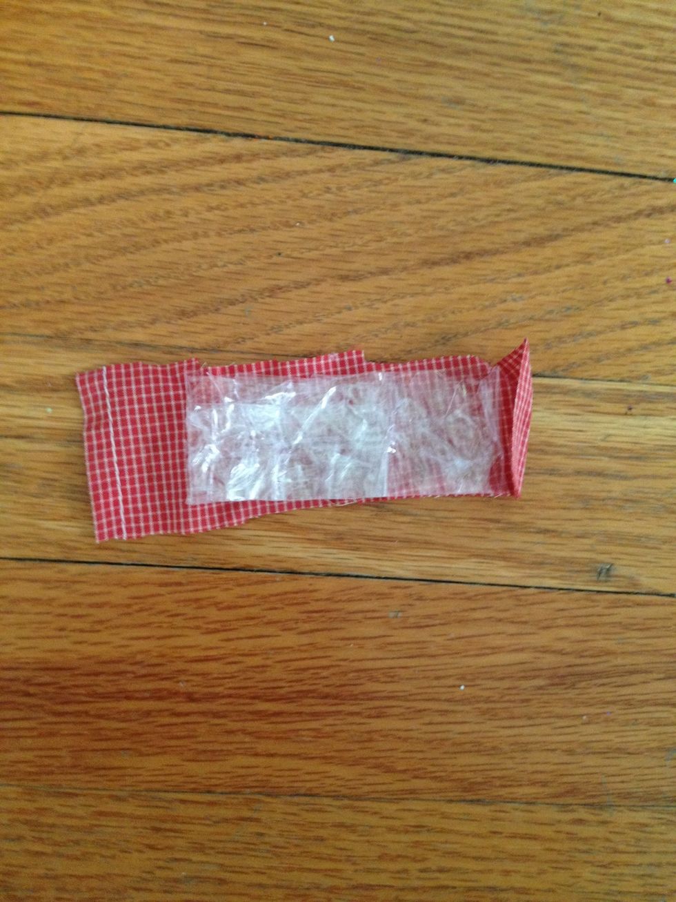 Cut out a piece of red fabric roughly larger than the piece of tape.