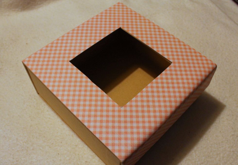 Cut out a rectangle from a sheet of 'Precious Memories' paper of 5x12'. Also cut out a square from the middle of the paper. Slightly fold the paper at three places and adhere the paper to the box.