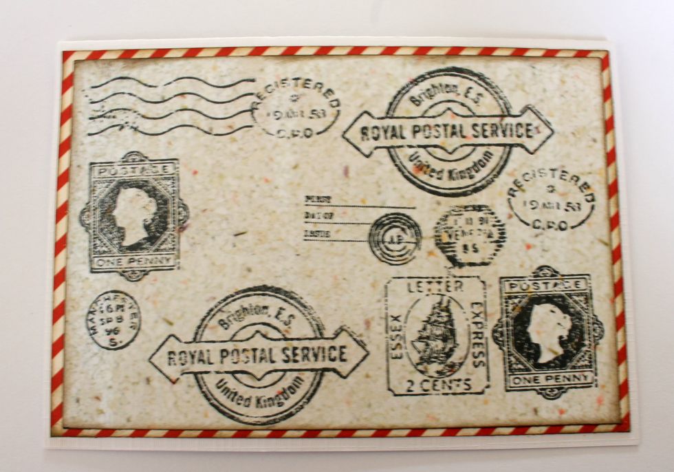 Cut out a rectangle of 5.5x3.4" from the "Adventure" paper and attach it on top of the red paper.