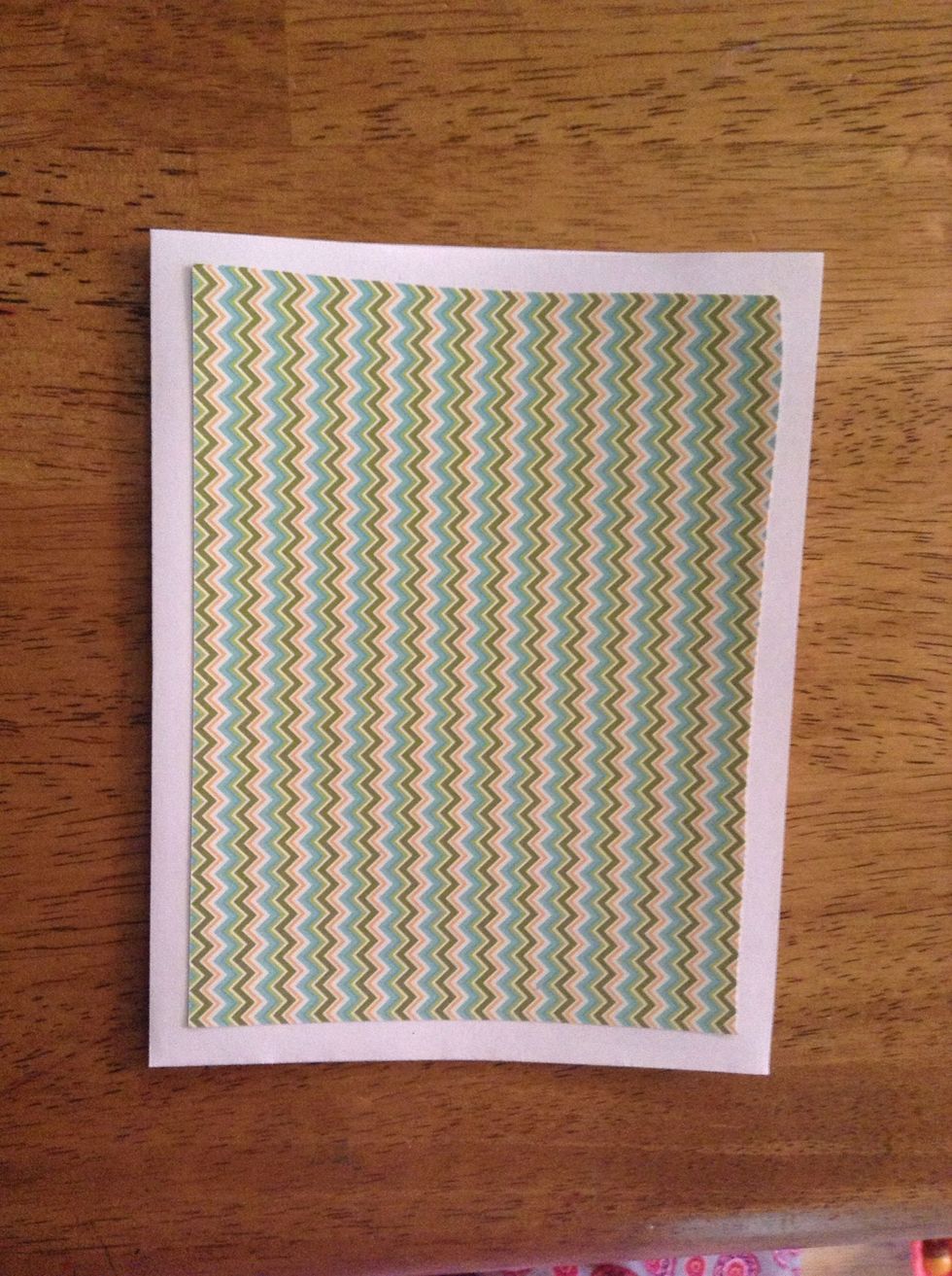 Cut out a rectangle of patterned paper slightly smaller than the front of the card. Glue it in the center. This paper can be found in any arts&craft store.