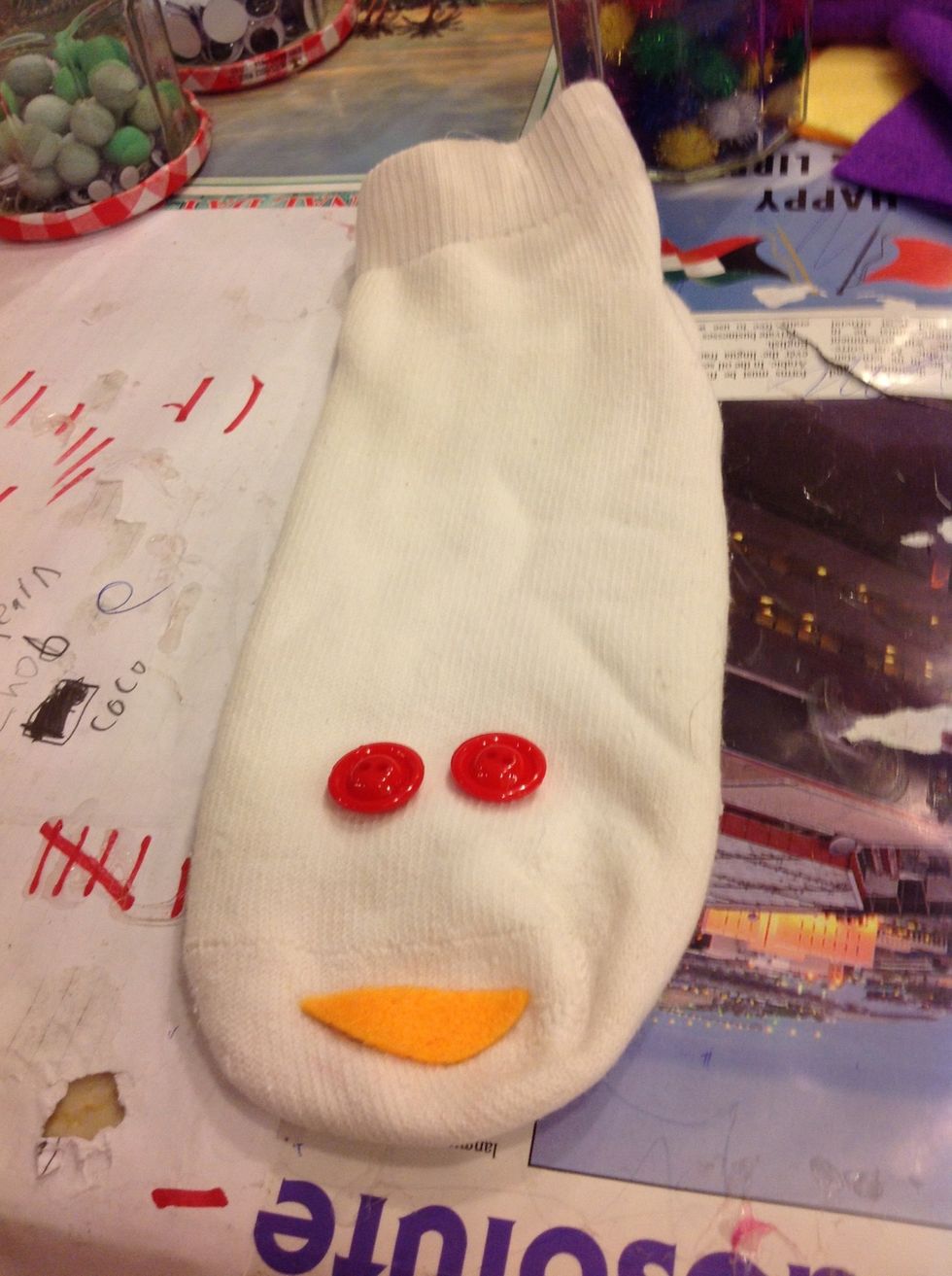 Cut out a smile with your felt and glue it under the seam ( the line at the end of the sock) with your glue gun