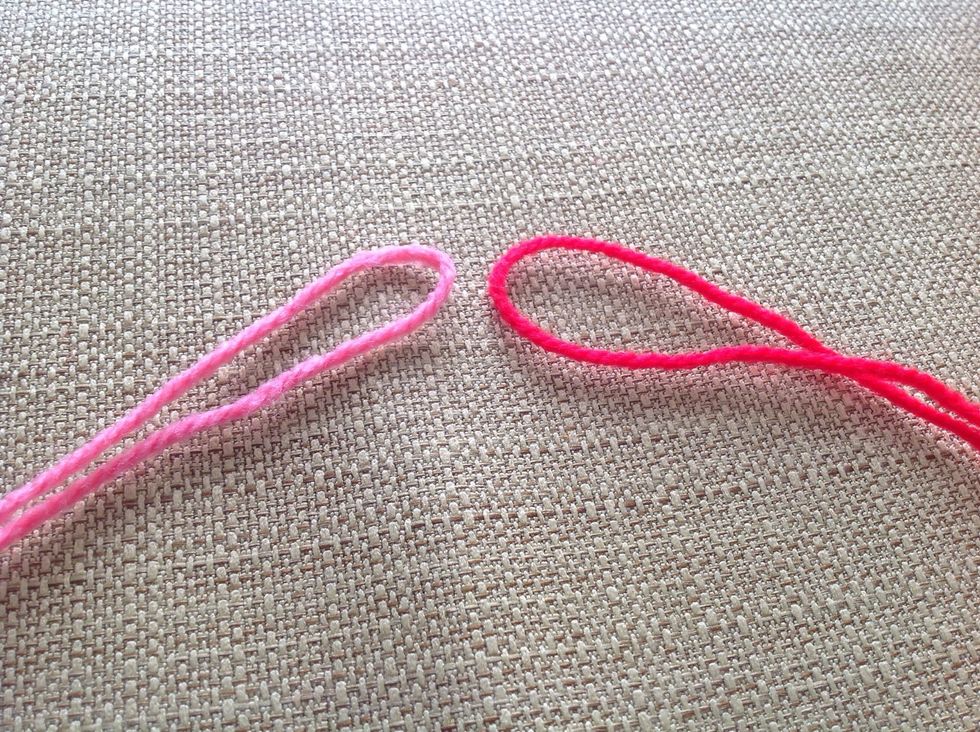 Cut out about about 1 meter of string for each color, then fold them in half like this.
