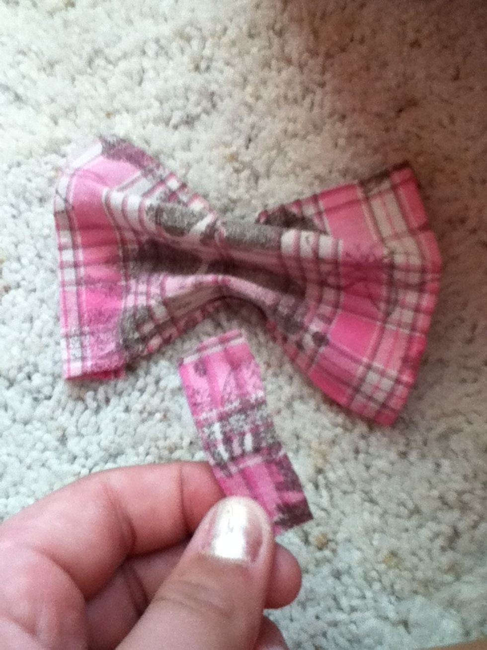 Cut out another piece of fabric and wrap around the center of your bow . Glue it down after