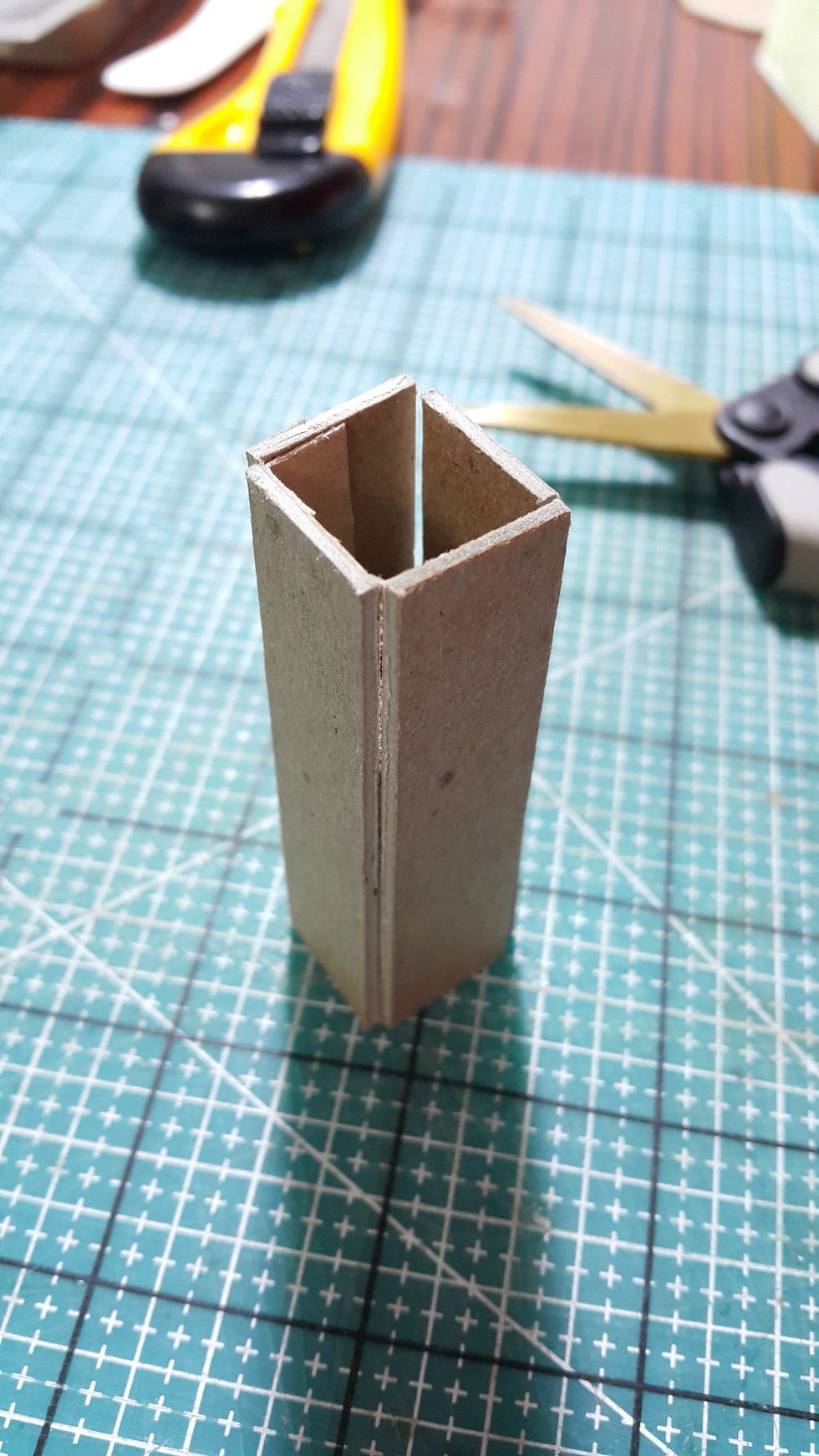 Cut out chipboard pieces and form into shape, as the standing base of the fan