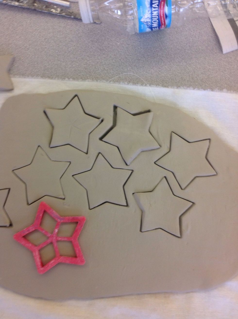 Cut out shapes, strategically fitting in as many as you can. Roll up excess, wedge it and roll out a new slab to make more, if needed.