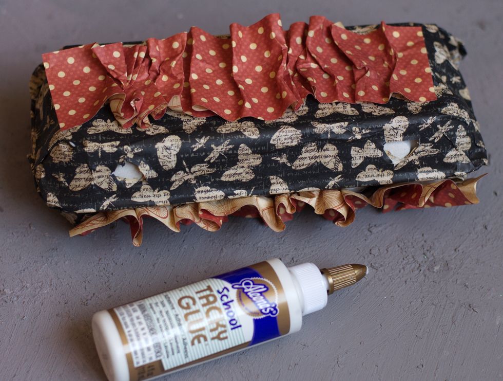 Cut out stripes from DIY Craft Paper-Bicycles & Polka Dots Graphic 45.The stripes should be two times longer than the box. First spray them with water, then fold them in zig-zag way and stick them