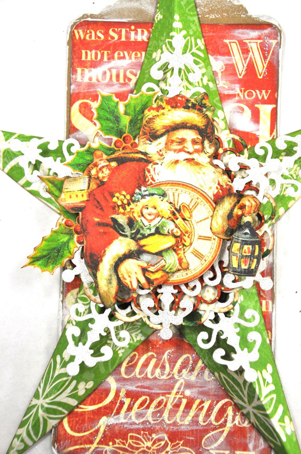 Cut out the father Christmas and a small clock from your sheet of "Jolly old elf". Cut around father Christmas' arm and tuck the clock under, adhere it to your circle with foam squares.