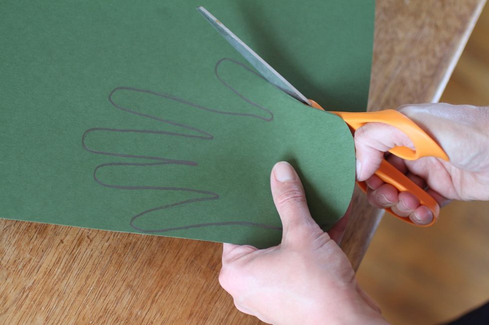 Cut out the outline of your hand and place it on another piece of green paper, tracing it with the pencil.
