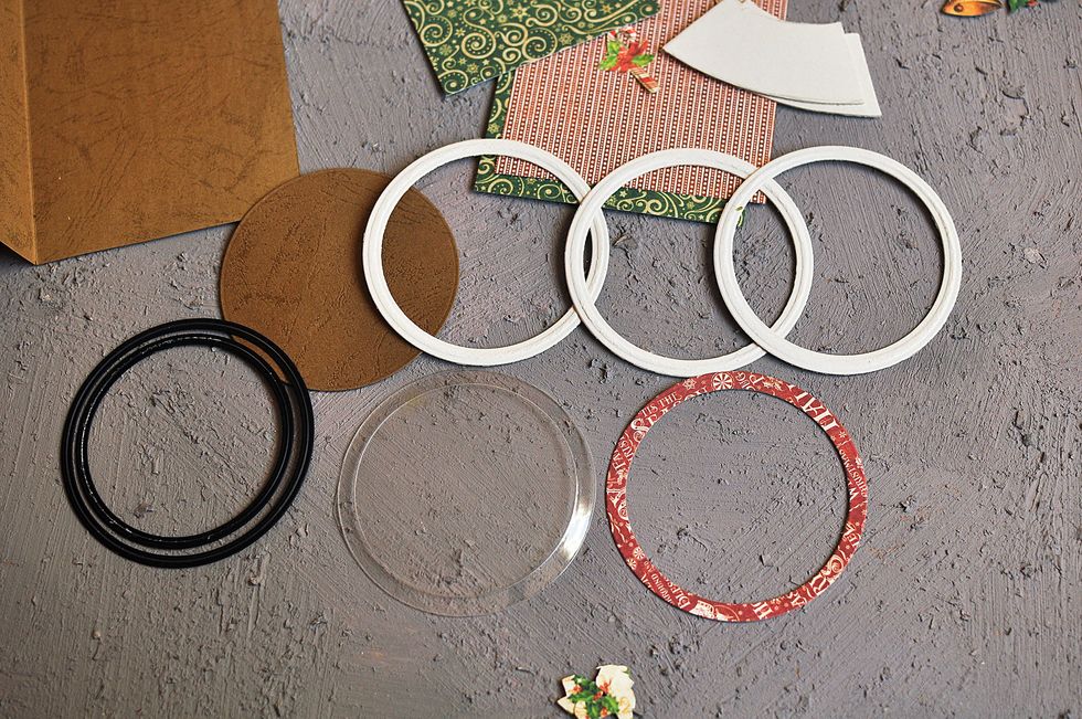 Cut out the round frames of thick carton, paper and circle of transparend plastic with DIES Scrapberrys