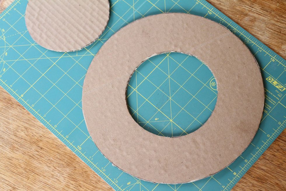 Cut out the smaller circle, leaving you with a doughnut shaped piece of cardboard about two inches wide all the way around. This will be the back of your wreath.