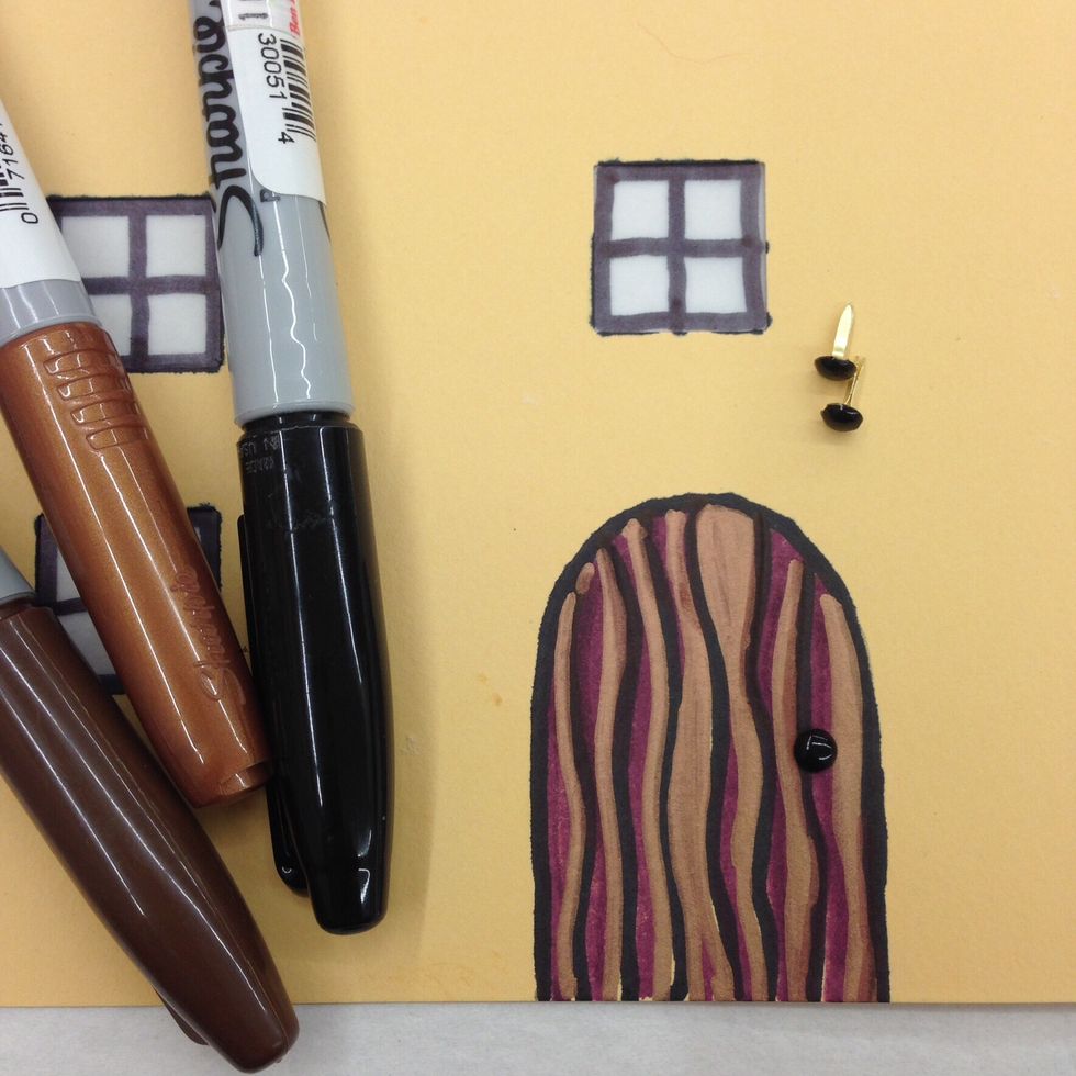 Cut out the template for the door. Trace it on a piece of paper and cut out. If you like, you can decorate it with markers. Glue it in place on the front of your house.