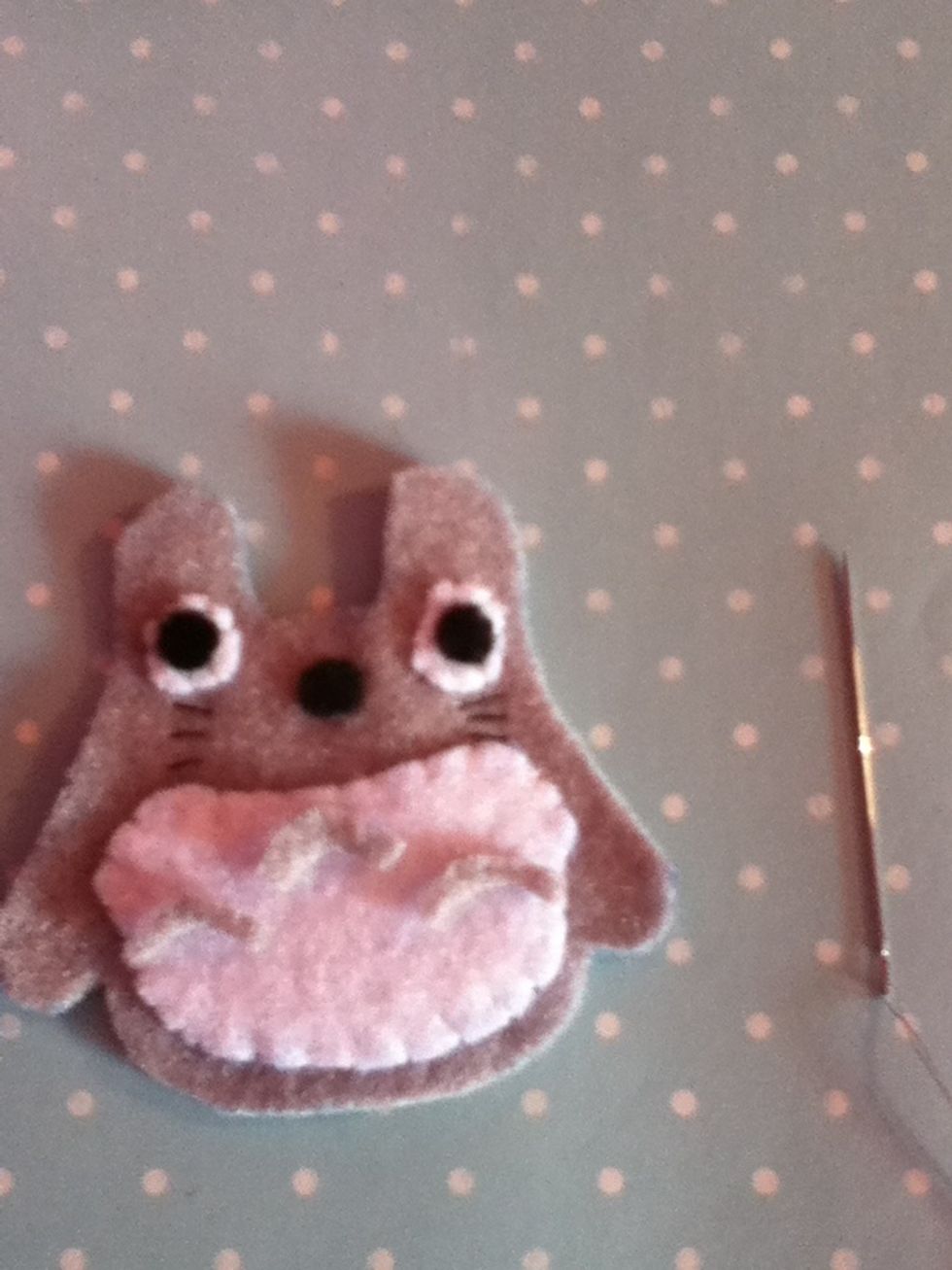 Cut out three arched shapes out of grey felt and sew them on using a back stitch