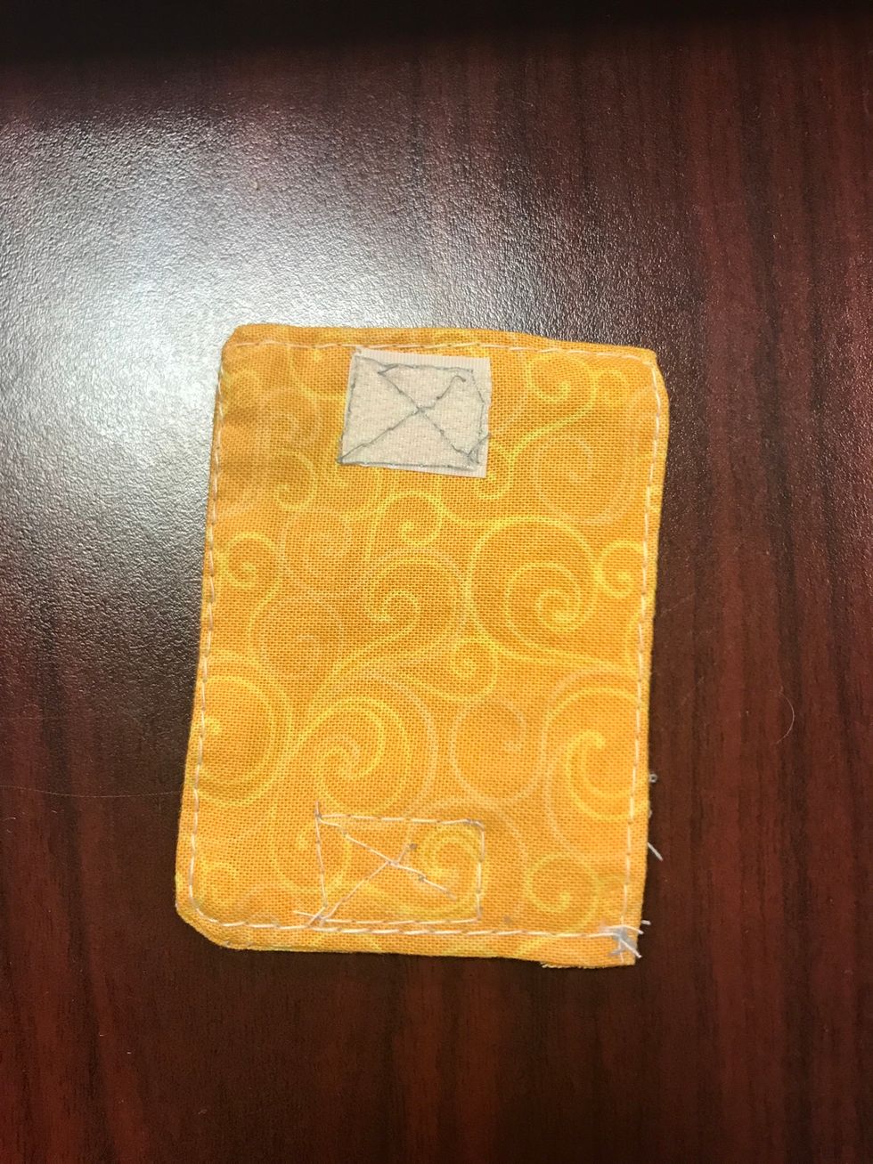 Cut out two 1x1 inch squares of velcro and pin to the fabric, placing one on the outside and the other on the opposite inside so that when it\u2019s closed it holds the earbuds in place.